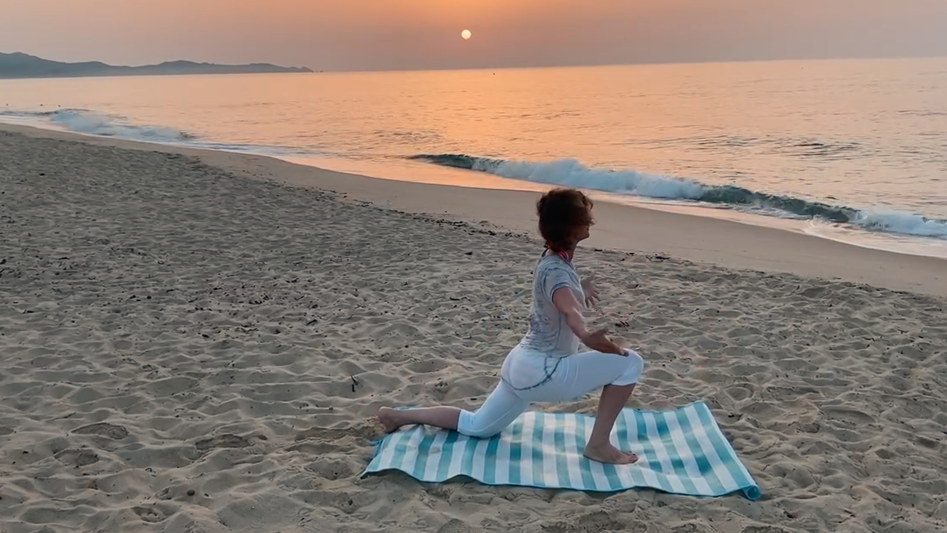 Susanne Fuchs in öffnender Yoga-Haltung am Strand